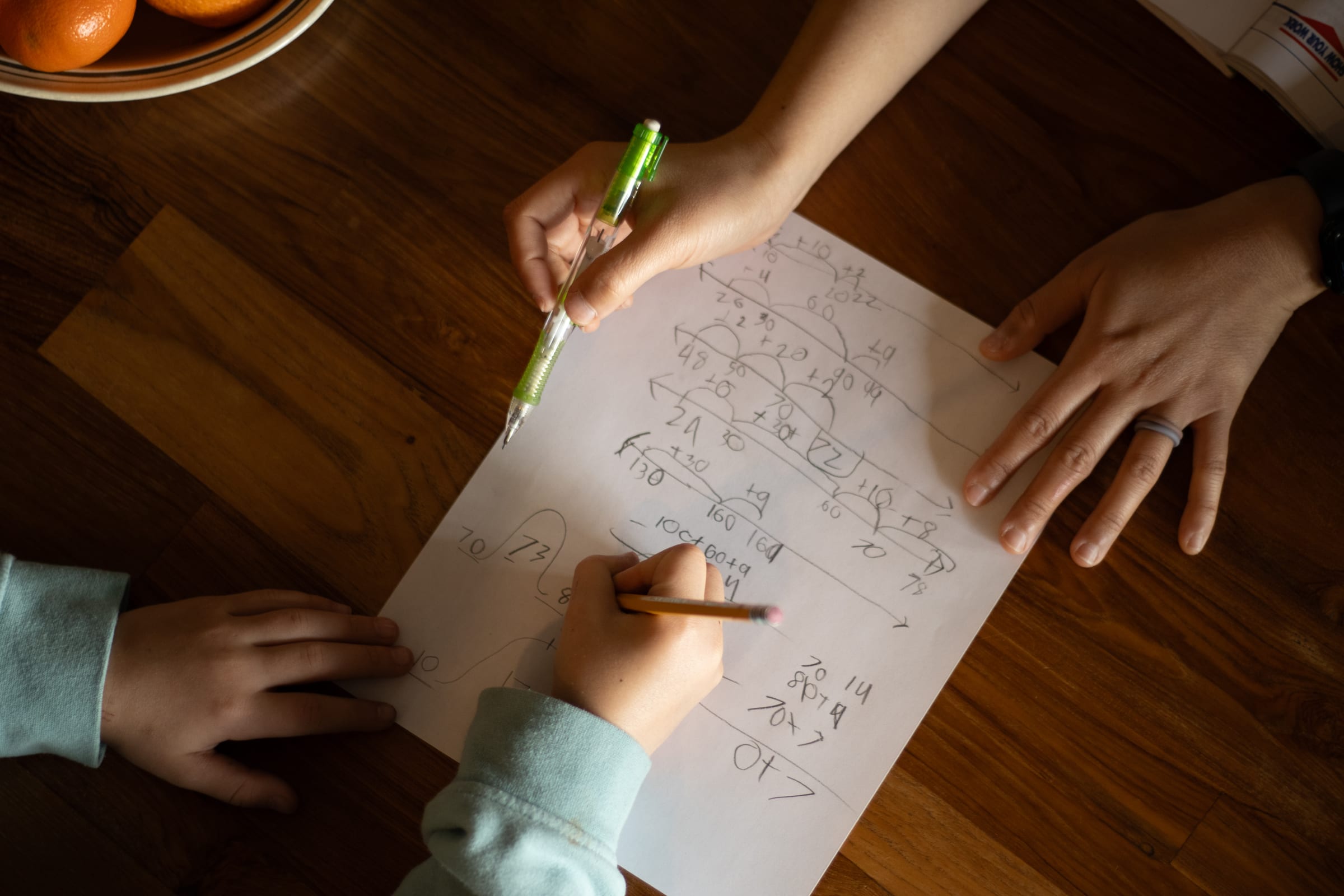 Overhead view of a math lesson in progress on a tutoring table